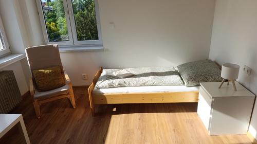 a small bedroom with a bed and a chair at Na břehu Olše in Český Těšín