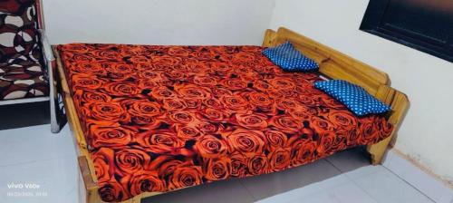 a bed with a red comforter with red roses at Peaceful Stay in Malvan