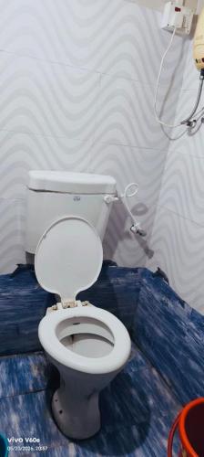 a bathroom with a white toilet in a room at Peaceful Stay in Malvan