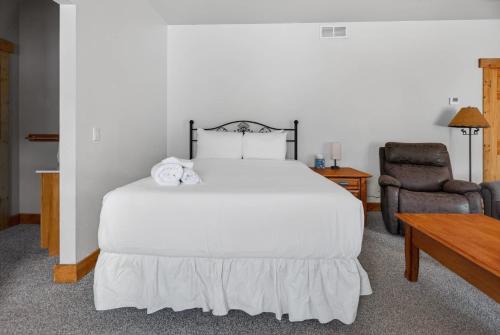 a bedroom with a white bed and a chair at 1BR Mountain View Studio with Fireplace Deck Views in Fort Collins