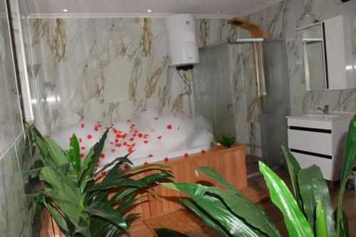 a bathroom with a white tub in a room with plants at Komitski Konak & Spa in Plešanci