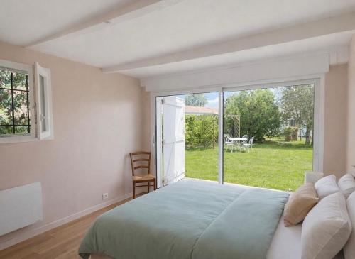 a bedroom with a bed and a large window at House with large garden Audenge in Audenge