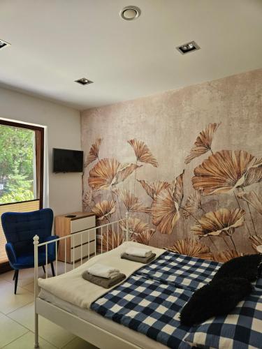a bedroom with a bed and a blue chair at Apartamenty Wisełka in Wisełka