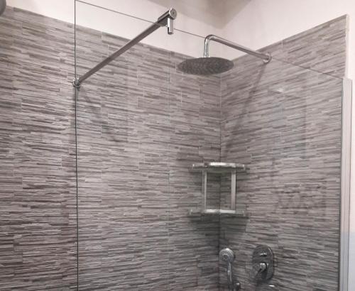 Un baño con ducha con pared de piedra. en House Maestrale by Holiday World, en Moneglia