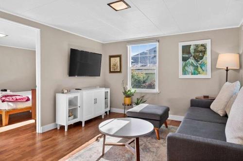 a living room with a couch and a tv at The McKinley Cottage in Boise