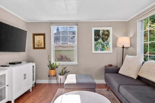 a living room with a couch and a tv at The McKinley Cottage in Boise