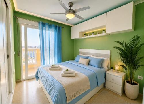 a bedroom with a blue bed with a ceiling fan at La Manga apartamento Siesta in San Blas