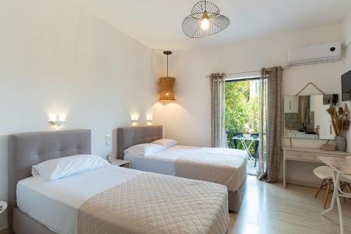 a hotel room with two beds and a bathroom at Tsimiklis Apartments in Finikounta