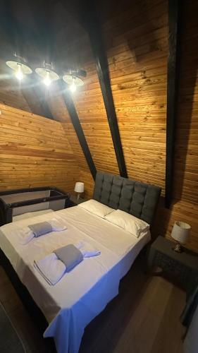 a large bed in a room with a wooden wall at Lefkali HOME in Çınarlık