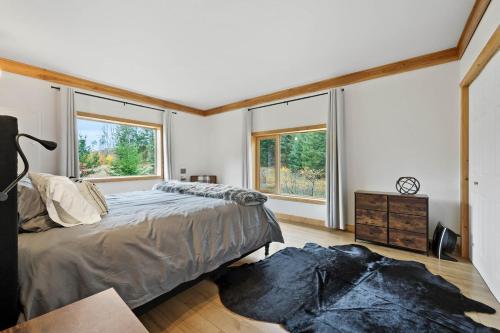a bedroom with a bed and two windows at Cabin on Private 8-acre Lake in Clearwater