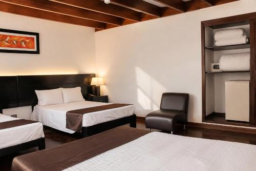 a hotel room with two beds and a chair at Deville Inn in Lima