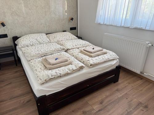 a bedroom with a bed with two towels on it at Radnóti Apartman Győr in Győr