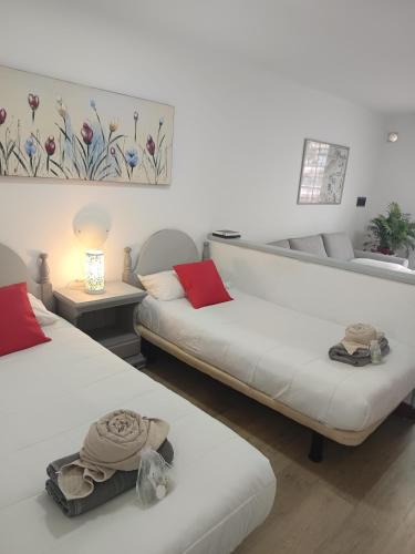 a living room with two beds and a couch at il centro delle vacanze in Playa de las Americas
