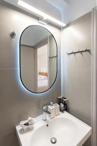 a bathroom with a white sink and a mirror at Tsimiklis Apartments in Finikounta