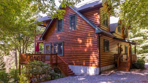 a log home with a porch and a balcony at Windswept Vistas in Boone