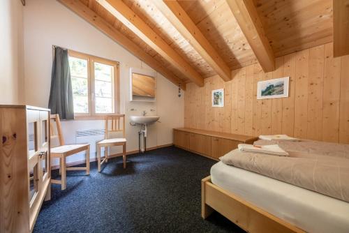 a room with two beds and a sink in it at Tällihütte in Gadmen