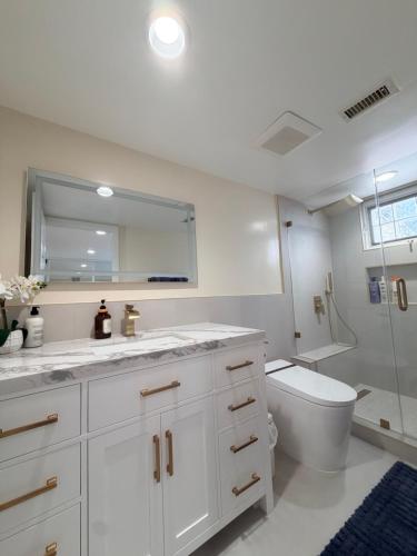 a white bathroom with a toilet and a mirror at Sunset Beach Paradise Home in Sunset Beach