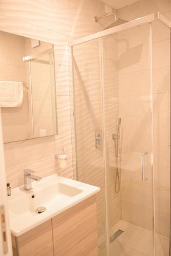 a bathroom with a sink and a shower at MiraMar Hotel in Shëngjin