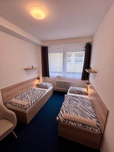 a room with two beds and a window at Sporthostel Scandinavia in Prague