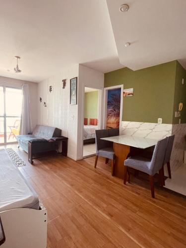 a living room with a table and chairs and a bed at FLAT frente Mar Green Diamond in Vila Velha