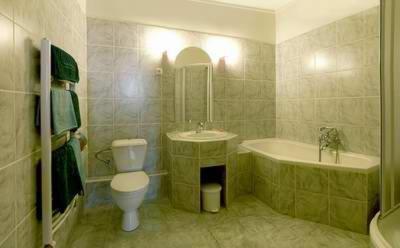 a bathroom with a toilet and a tub and a sink at Hotel Barbarossa in Cheb