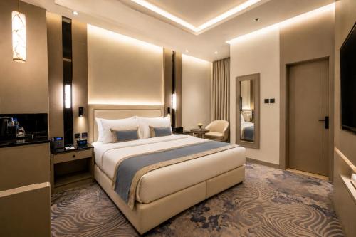 a hotel room with a large bed and a bathroom at Luxury Night Hotel Al Yasmin in Riyadh