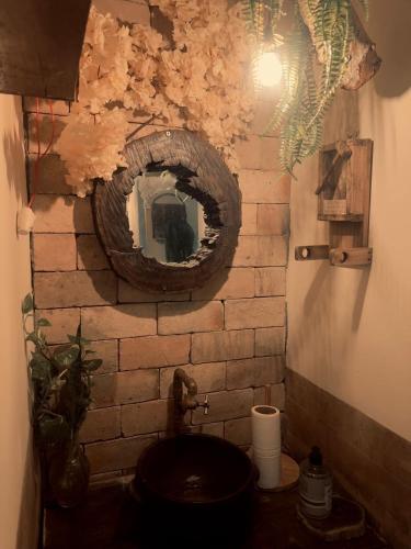 a bathroom with a mirror on a brick wall at Pousada Berro do Bode in Cabaceiras