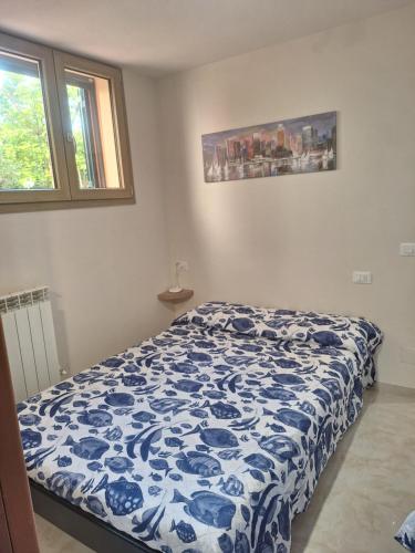 a bedroom with a blue and white comforter on a bed at La taverna del puntone in Puntone di Scarlino