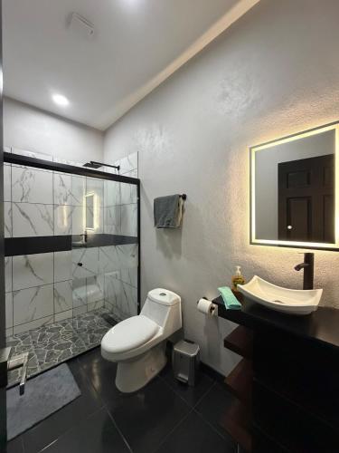 a bathroom with a toilet and a sink and a shower at TinyHouseMX2 Comodidad, lujo y playa que se disfruta in Barre De Navidad
