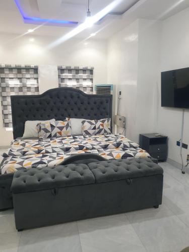 a large bed in a room with a television at Sbk3apartments in Ologode