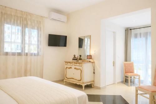 a bedroom with a bed and a tv on the wall at green & blue villa in Glykadi