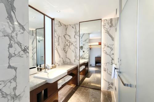 a bathroom with a sink and a mirror at Changsha Rama-da by Wyndham Wuyi Square-Near Metro-Business Center in Changsha