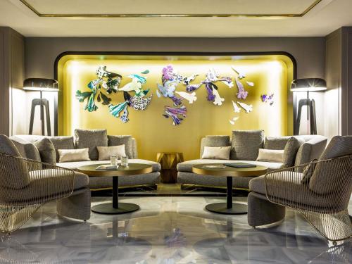 a lobby with two couches and butterflies on the wall at Sofitel Lisbon Liberdade in Lisbon