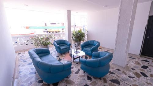 a waiting room with blue chairs and a table at Damar Hotel Collection Valledupar in Valledupar