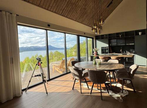 a camera on a tripod in a kitchen with a table at LyNora - A private fjord retreat in Indre Ravelseidet