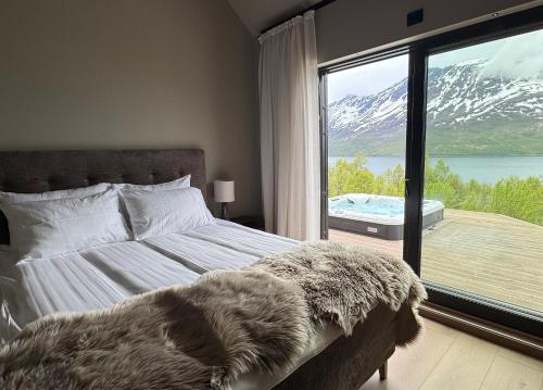 a bedroom with a bed with a view of a mountain at LyNora - A private fjord retreat in Indre Ravelseidet