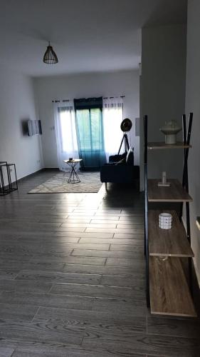 a living room with a wooden floor and windows at Résidence LE MÄYSA CORAIL in Sada