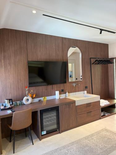 a bathroom with a sink and a tv on the wall at NOMA Rooms Murter in Murter