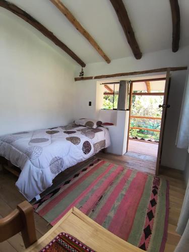 a bedroom with a bed and a rug on the floor at Casa Hospedaje Saywa in Lamay