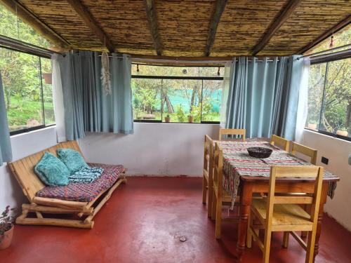 a dining room with a table and chairs and windows at Casa Hospedaje Saywa in Lamay