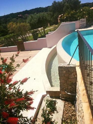 a swimming pool in a house with a landscaping at Hôtel Maora Village in Bonifacio