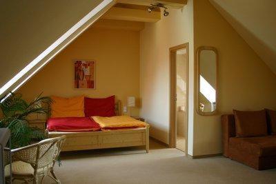 ein Schlafzimmer mit einem Bett in einem Zimmer im Dachgeschoss in der Unterkunft Hotel Barbarossa in Cheb