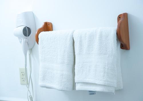 a towel rack with towels and a hair dryer at Hotel Los Corales in West End