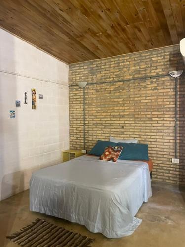 a bedroom with a bed in a brick wall at Monoambiente Privado in Luque