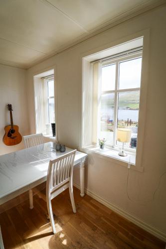 a dining room with a table and a window at Spacious 3-Bedroom Apartment with Comfy Beds in Central Vágur, Island of Suðuroy in Vágur
