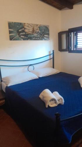 a bedroom with a blue bed with towels on it at Casa Frida in Solanas