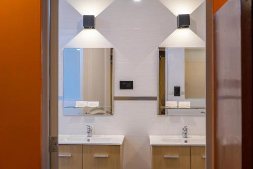 a bathroom with two sinks and two mirrors at Hotel Sol de Belén Cajamarca in Cajamarca