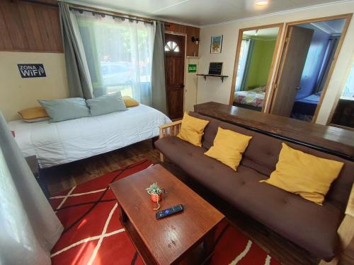 a living room with a couch and a bed at Cabaña Aldea 31 in Coihaique