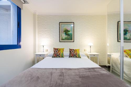 a bedroom with a large white bed with two pillows at Suites Garden Apartamento 16 in Las Palmas de Gran Canaria