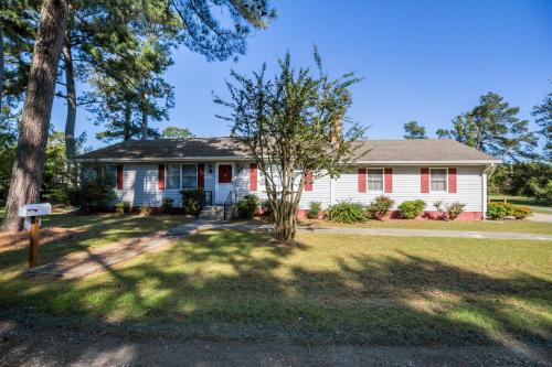 a white house with a tree in the yard at Happy Pines in Chincoteague